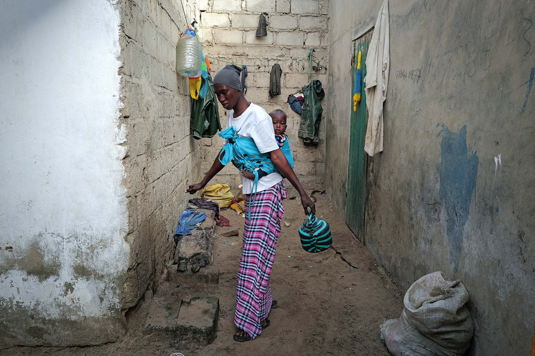 FASS BOYE, SENEGAL: Months after a failed attempt to reach Europe by sea, an impoverished mother prepares for her morning wash outside her home.